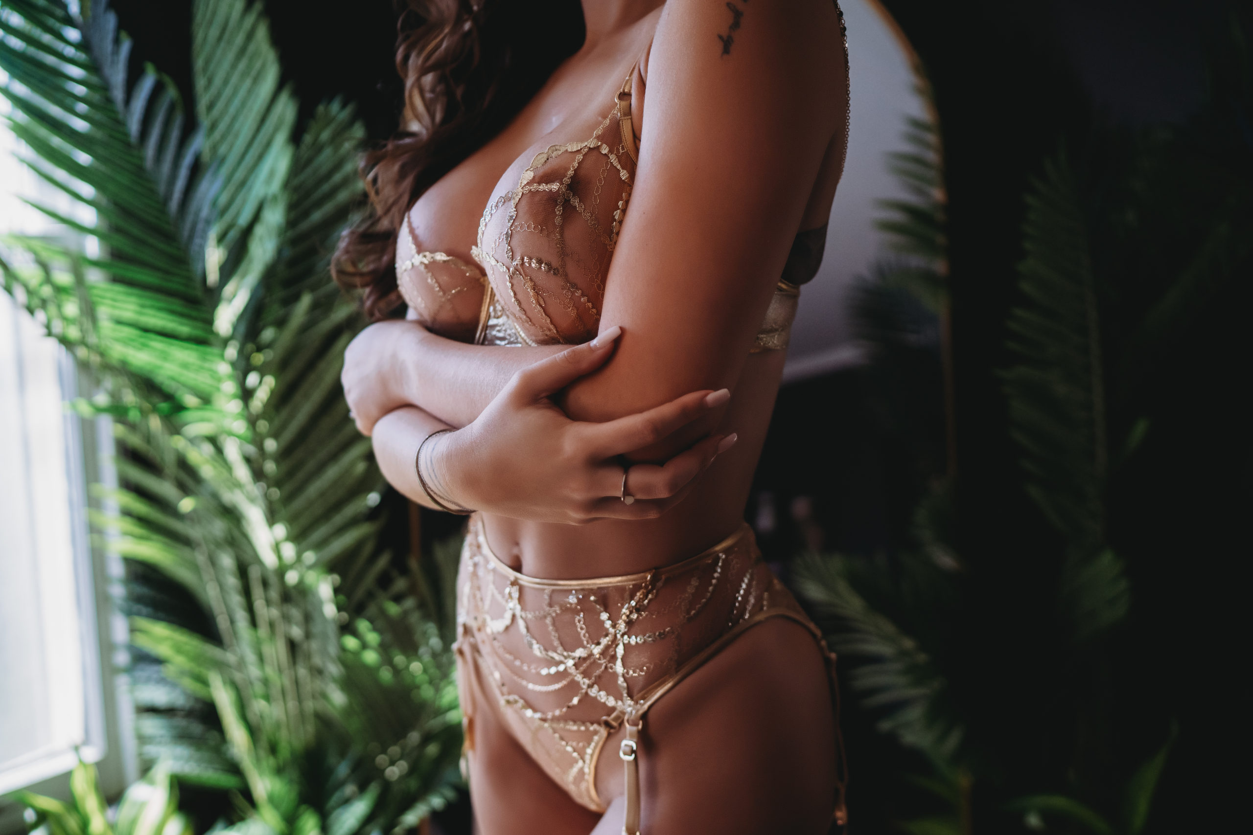 Woman with folded arms dressed in gold lingerie